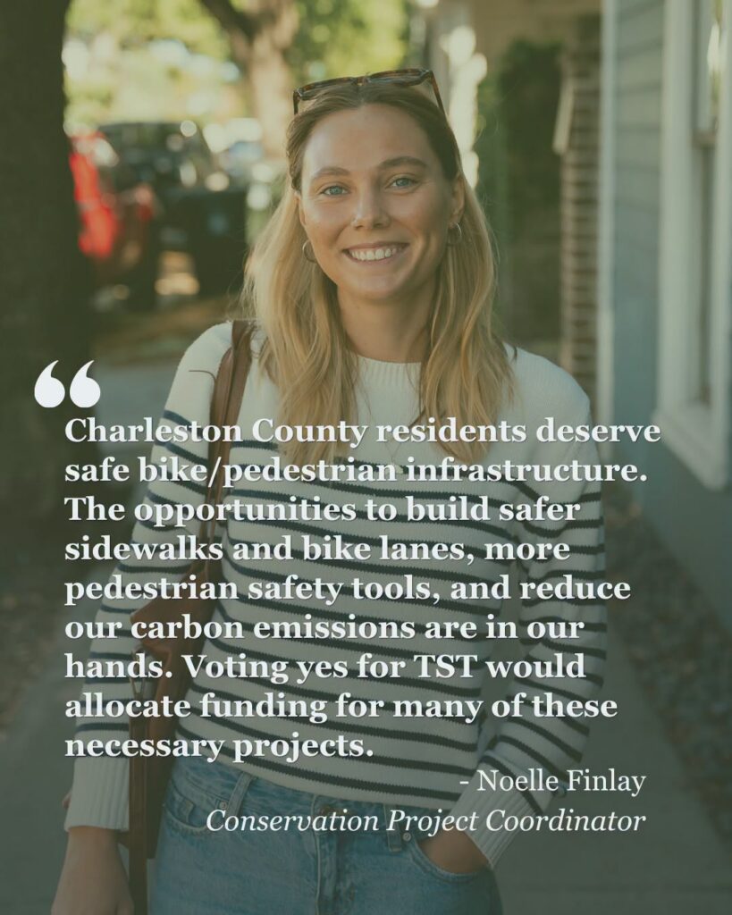 A person, smiling at the camera, walks down the street in Charleston, SC